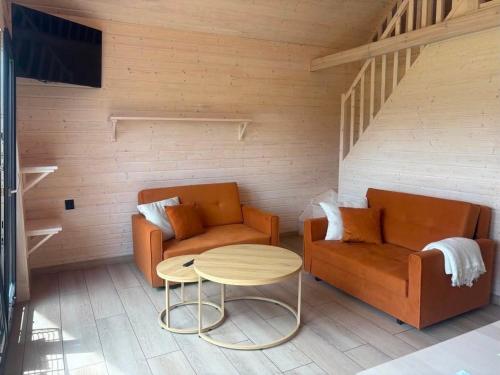 a living room with two couches and a table at PAKLADA Domek całoroczny 2 in Bak