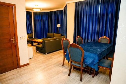 a living room with a blue table and chairs and a couch at Khazri Resort & Villas in Baku