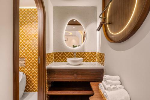 a bathroom with a sink and a mirror at Vista Del Sol Hotel in Danang
