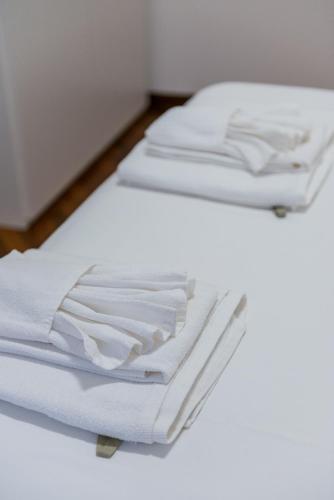 two white towels sitting on top of a bed at Effealatapartments - Appartamento del Duca in Senigallia