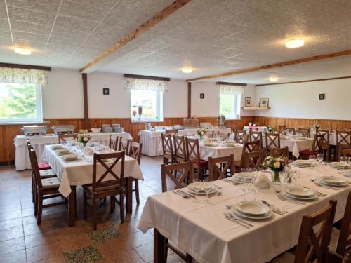 a large room with tables and chairs with white tablecloths at Relaxační centrum Orion in Roudná