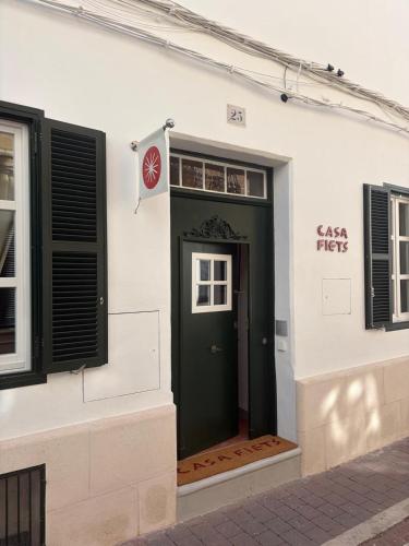 a green door on the side of a white building at Hotel Casa Fiets in Alaior