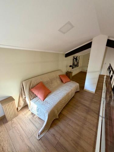 a bedroom with a bed with two orange pillows on it at Résidence les Caraibes in Sérignan