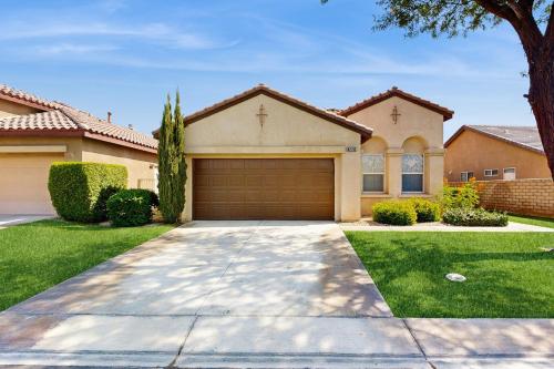 a house with a garage in a yard at Tranquil Desert Sanctuary in Indio