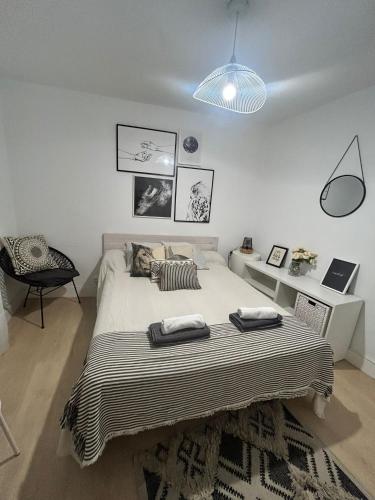 a bedroom with a large bed with two towels on it at Suite Estébanes in Zaragoza
