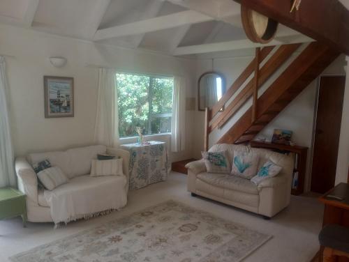 a living room with two chairs and a table at Beside the lagoon - Waikanae Beach in Waikanae