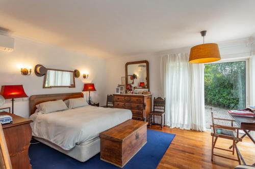 a bedroom with a bed and a desk and a mirror at Charming House in Cascais in Alcabideche