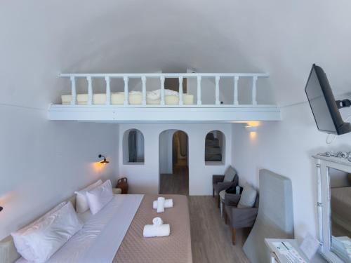 a living room with a couch and a balcony at Diamond on the cliff Hotel&Suites Imerovigli in Imerovigli