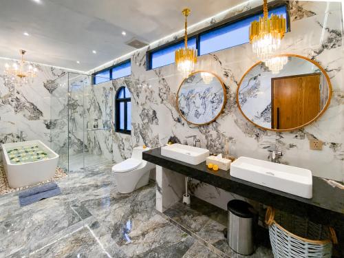 a bathroom with two sinks and a tub and mirrors at Mountain Healing Villa by Nagisa Bali in Baturiti
