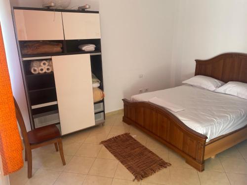 a small bedroom with a bed and a chair at Eretz in Tirana