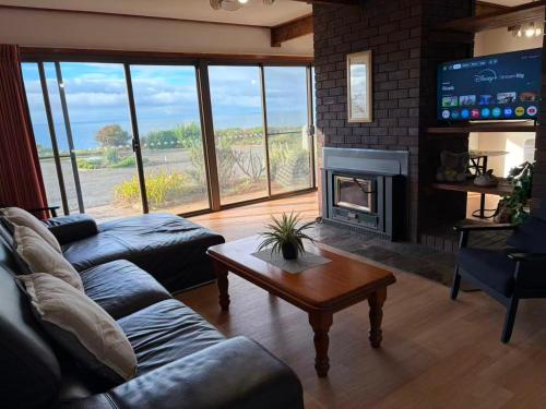 a living room with a couch and a fireplace at The Bass Horizon - 5 bedrooms - 10 people - Bass Strait View in Devonport