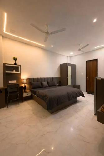 a bedroom with a large bed and a desk at OddbirdStays in Indore