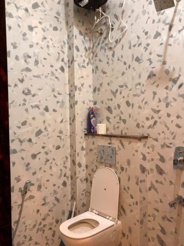 a bathroom with a toilet and a shower at OddbirdStays in Indore