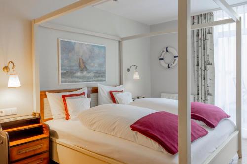 a bedroom with two beds and a window at Hotel Friese-up AnnerSiet- in Norderney