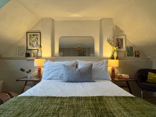 a bedroom with a large bed with two lamps and a mirror at 3 Bedrooms, 3 Double Beds, 6 Guests, Countryside Thatched Cottage in Four Marks