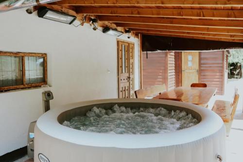 a jacuzzi tub in a room with a table at LIKe A cottage in Perušić