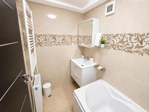 a bathroom with a toilet and a sink and a mirror at ARKADIA 2 BR APARTMENTs in Bucharest