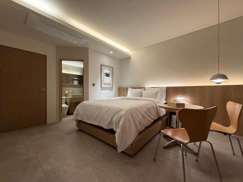 a bedroom with a bed and a table and chairs at SODO Hotel in P'aju
