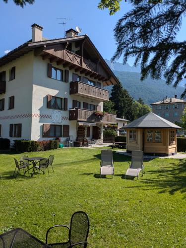 a building with chairs and tables in the grass at Chalet Meridiana in Bormio