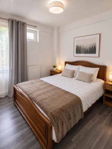 a bedroom with a large bed and a window at ARKADIA 2 BR APARTMENTs in Bucharest