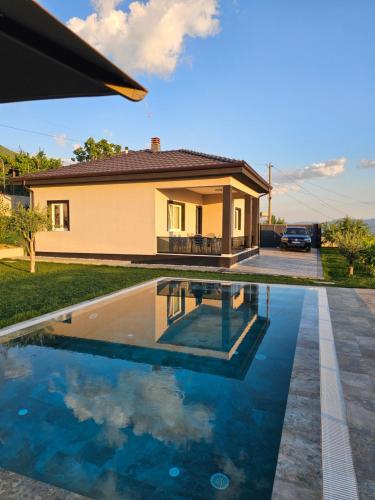 a house with a swimming pool in front of a house at Vila 1985 in Tirana
