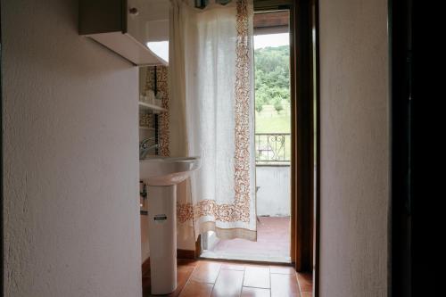 a bathroom with a sink and a door with a window at Al Vecchio Convento in Portico di Romagna