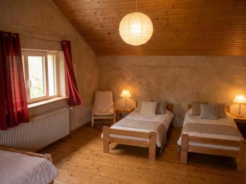a bedroom with two beds and a window and a lamp at Domaine de Marmonfosse in Taintrux