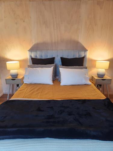 a bedroom with a large bed with two lamps at Warkworth Barn Retreat in Warkworth