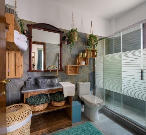 a bathroom with a sink and a toilet and a mirror at Casa Dell Artista with private jacuzzi in Kos