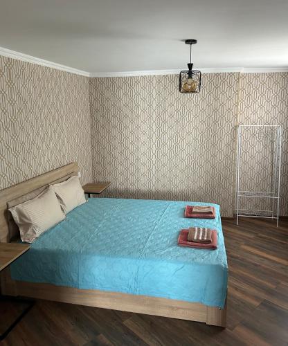 a bedroom with a bed with a blue comforter at Kostas guest house in Borjomi