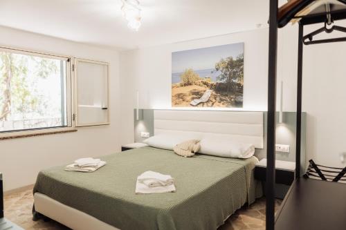a bedroom with a bed with two towels on it at Casa Bianca Rais Gerbi in Finale