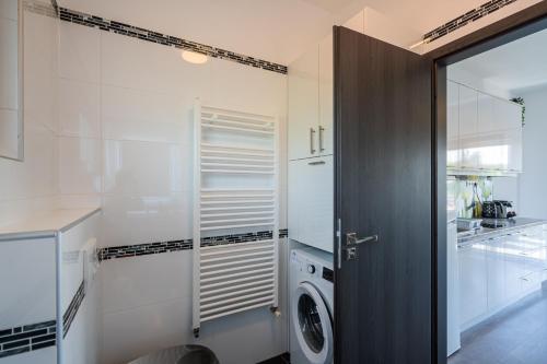 a laundry room with a washer and dryer next to a door at AH-Premium Rooftop Apartman in Zamárdi