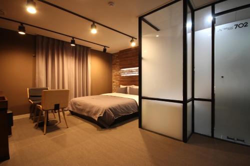 a bedroom with a bed and a table and a chair at Busan Station Dino Hotel in Busan