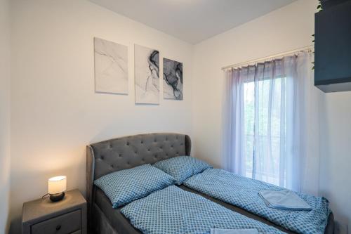 a bedroom with a bed and a window at AH-Premium Rooftop Apartman in Zamárdi