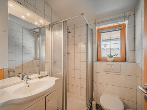 a bathroom with a sink and a shower and a toilet at Appartements Gamper - Alpline Appartements KG in Brixen im Thale