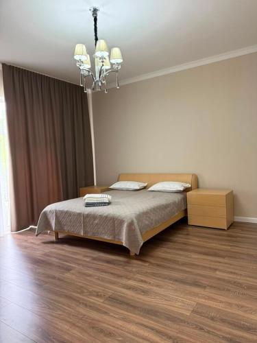 a bedroom with a bed and a chandelier at Карвен коттедж in Bulan Sogottuu