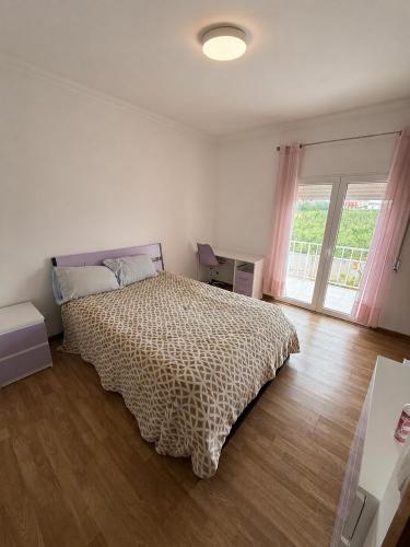 a bedroom with a bed and a large window at Montejunto Escape in Cadaval