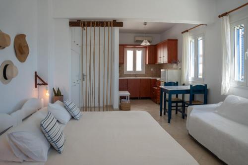a bedroom with a large white bed and a kitchen at Almira Studios in Kionia