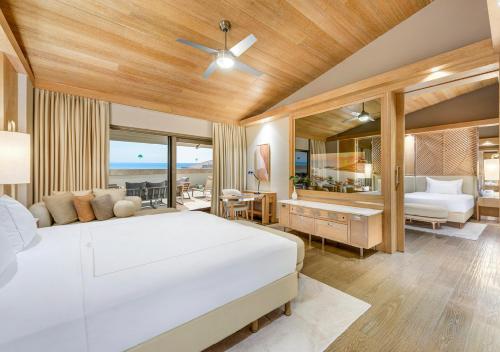 a bedroom with a white bed and a living room at Regnum Carya in Belek