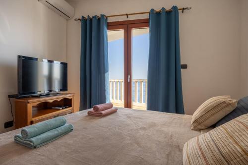 a bedroom with a bed with a television and blue curtains at Adrian in Rafailovici