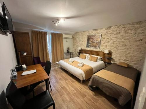 a hotel room with two beds and a desk at L'Escale des Alpilles in Rognonas