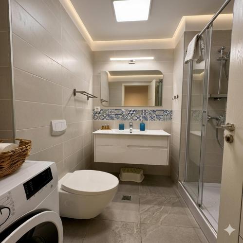 a bathroom with a toilet and a sink and a shower at MAYA Studio-Onix Blue with Private Parking, Mamaia Nord in Mamaia Sat/Năvodari