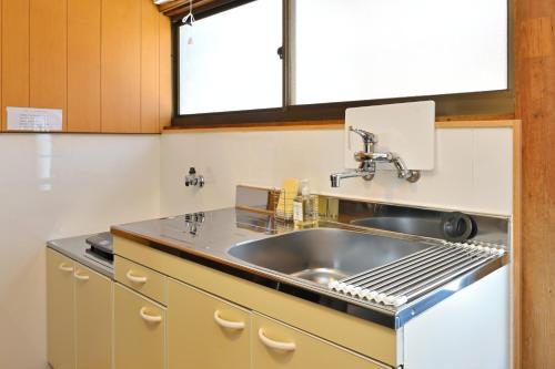a kitchen with a sink and a counter top at Shion 潮音 in Sakaide