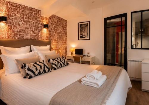 a bedroom with a large bed with towels on it at Au Fil de L eau in Albi