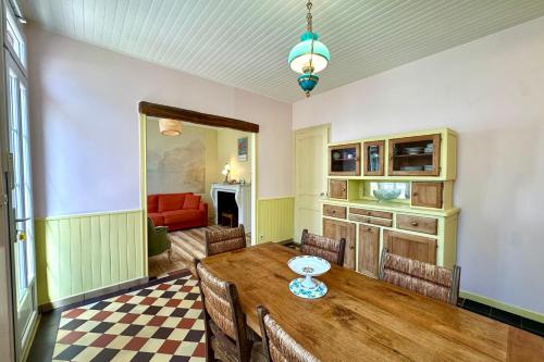 a dining room with a wooden table and chairs at Maison avec jardin entre St-Valery et Le Crotoy in Noyelles-sur-Mer