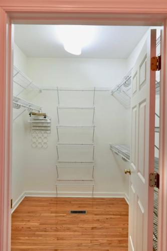 a hallway with white walls and white shelves at Elegant Suite King Bed, Queen Sofa, Fast WiFi in Fayetteville