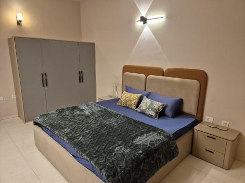 a bedroom with a large bed with blue sheets and pillows at The Palm Villa in Jaipur