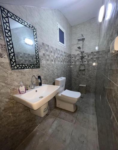 a bathroom with a sink and a toilet and a shower at Maison vue mer in Rafrāf
