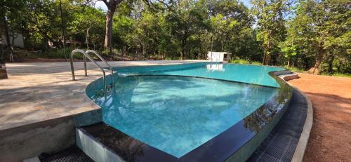 a swimming pool with blue water in a yard at Tamarind Tamarind Resort, Tourist Board Approved in Habarana