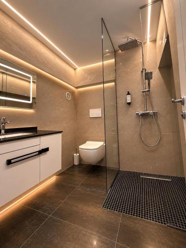 a bathroom with a shower and a toilet and a sink at ALZETA Aparthotel in Durrës